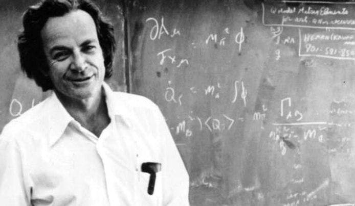 Richard Feynman standing in front of a chalk board