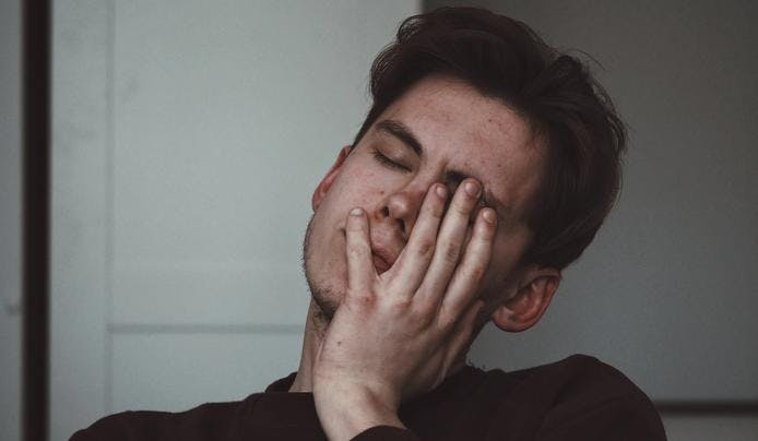 an image of a person lacking sleep and holding his head up