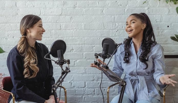 Two women talking on a microphone