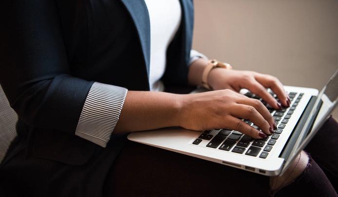 A person writing on a laptop